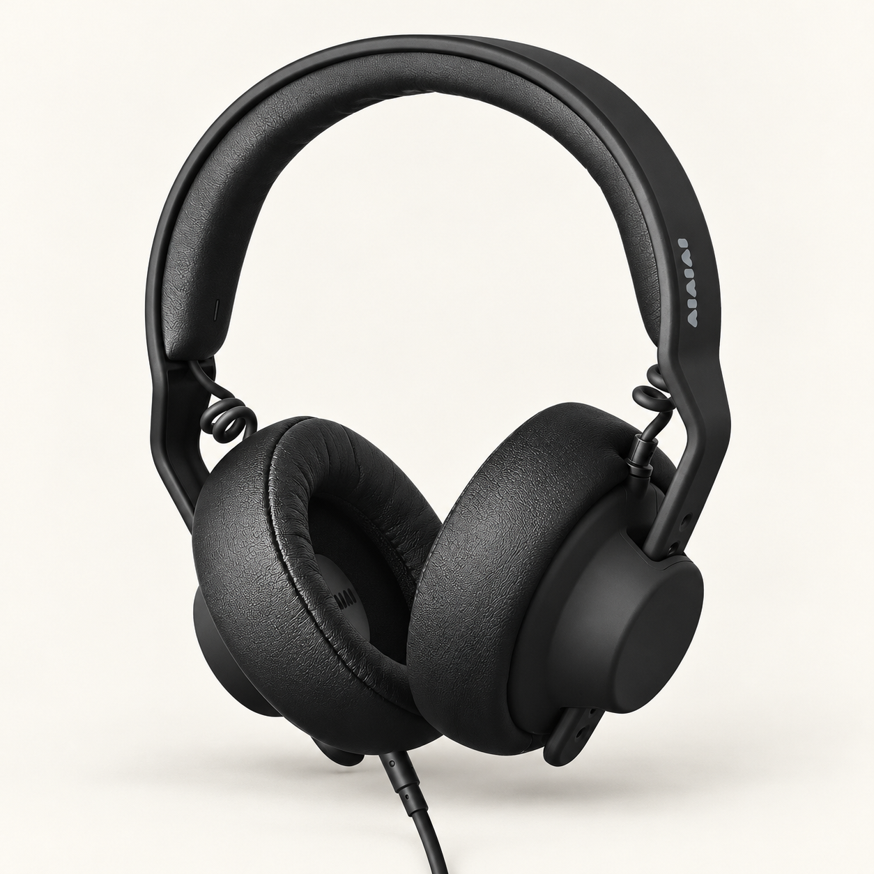 AI-generated illustration of black AIAIAI TMA-2 Studio XE wired headphones, with round PU-leather cushions, a padded arched headband and an attached straight cable.