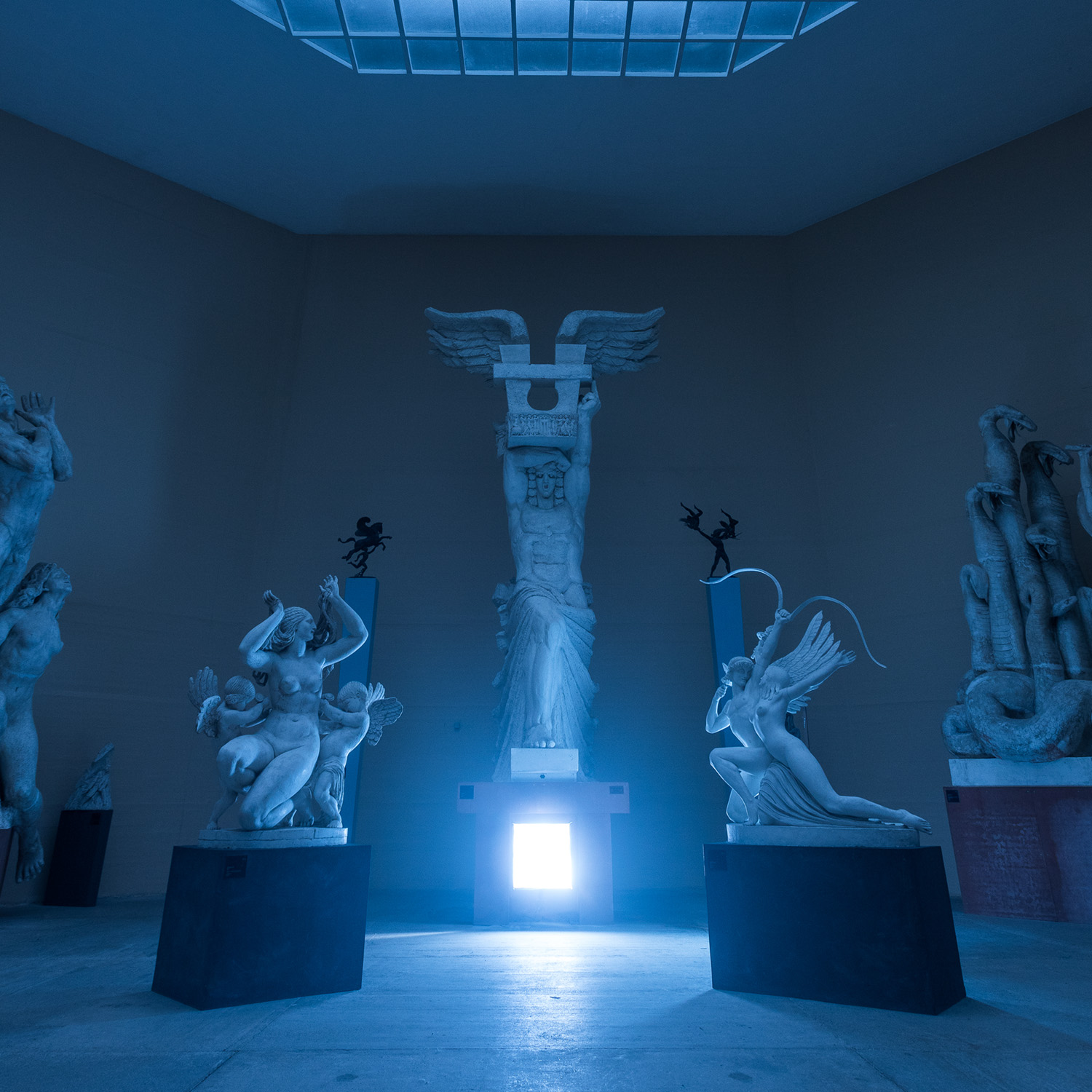 Age of Aquarius album artwork: a sculpture gallery bathed in deep blue light, with a bright square light low in the center.